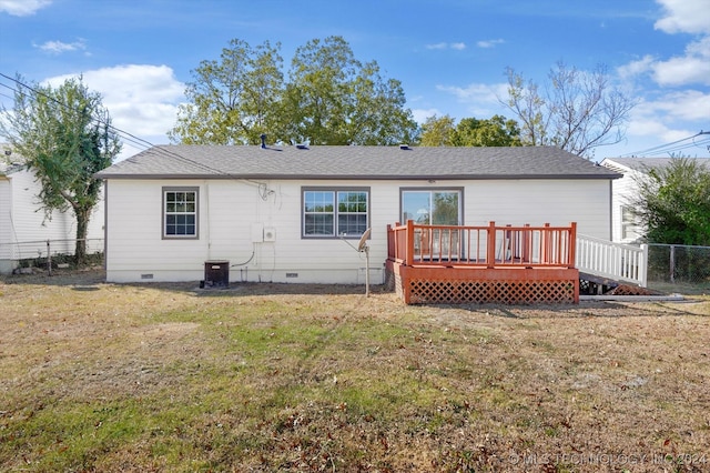 rear view of house with a deck and a yard