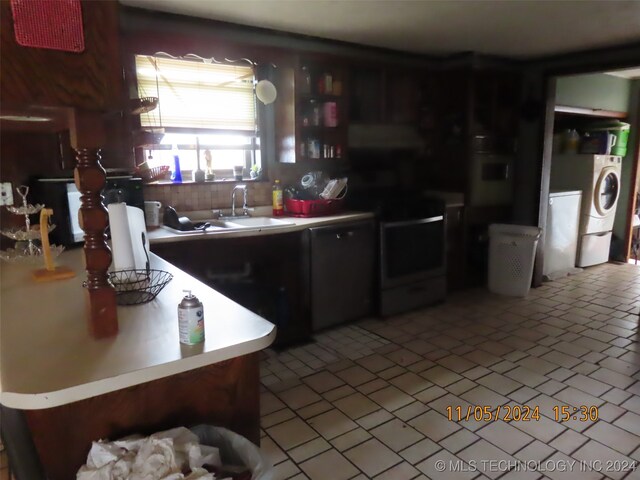 kitchen featuring black electric range oven, washer and clothes dryer, and sink