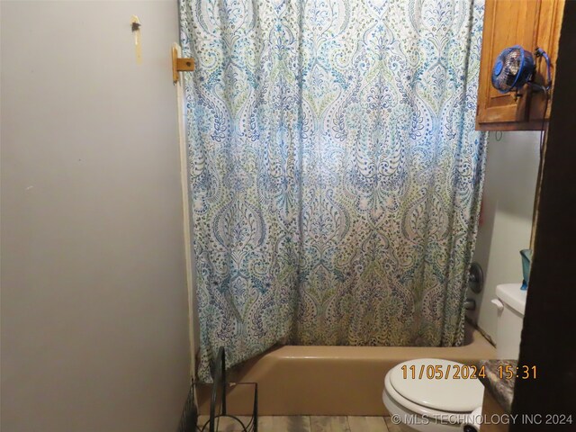 bathroom featuring shower / tub combo with curtain and toilet