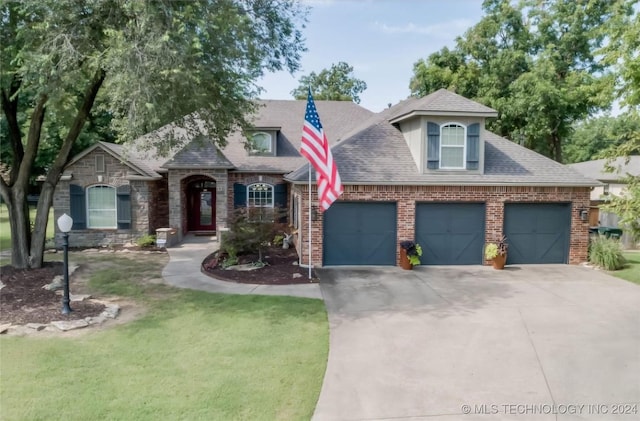 view of front of home featuring an attached garage, brick siding, a shingled roof, concrete driveway, and a front lawn