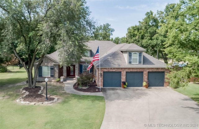 view of front facade featuring driveway, brick siding, an attached garage, and a front yard