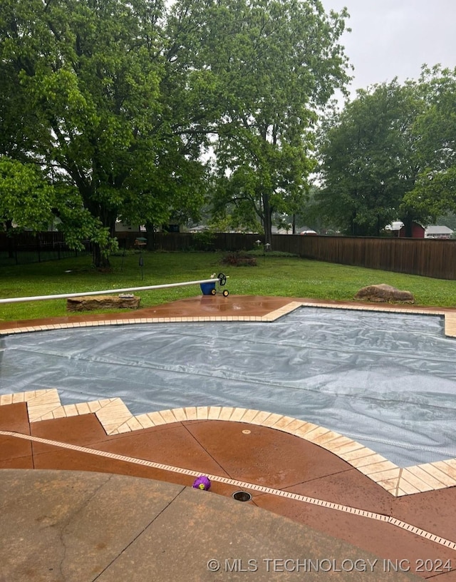 view of swimming pool with a lawn, a patio area, and a fenced backyard