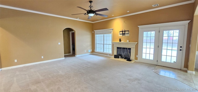 unfurnished living room with crown molding, light carpet, and ceiling fan