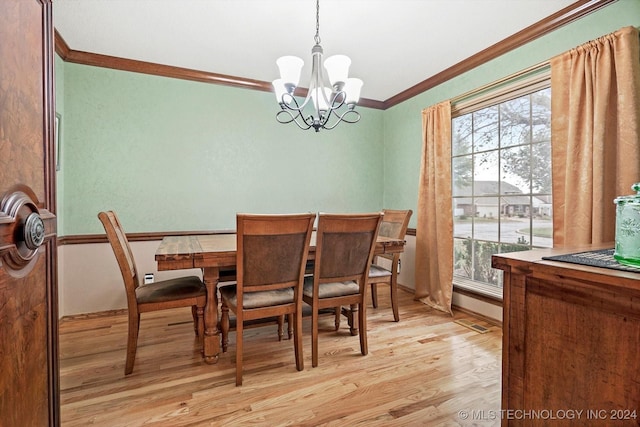 dining space featuring ornamental molding, a chandelier, and light hardwood / wood-style flooring