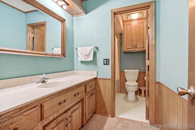 bathroom with vanity, wooden walls, and toilet