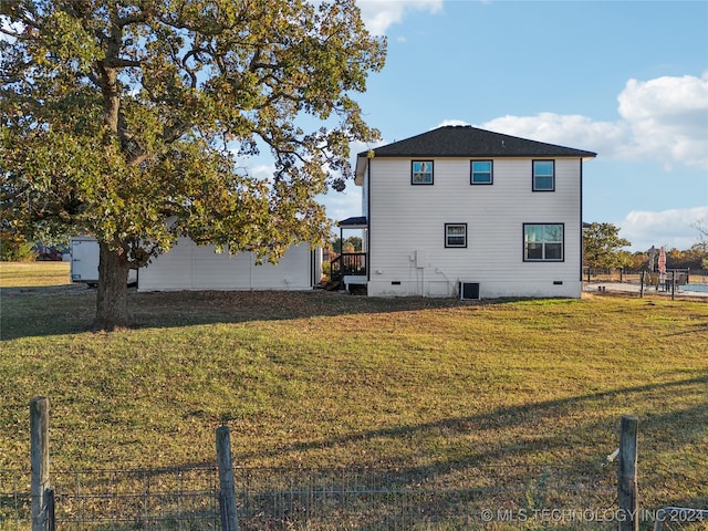 view of home's exterior featuring a garage, a lawn, and central AC