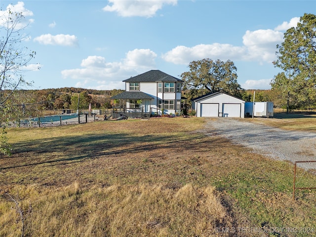 view of front facade featuring an outbuilding, a garage, and a front lawn