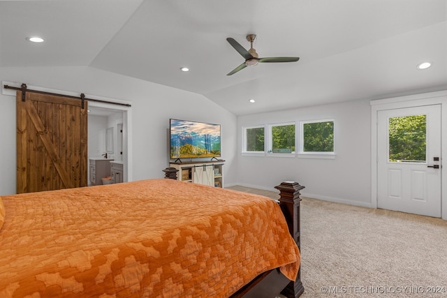 bedroom with a barn door, multiple windows, vaulted ceiling, and ceiling fan