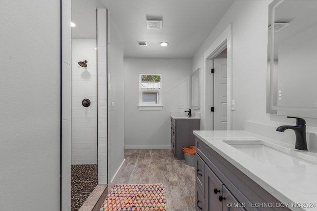 bathroom with vanity, wood-type flooring, and tiled shower