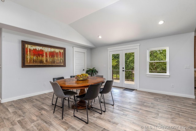 dining space featuring french doors, light hardwood / wood-style floors, and lofted ceiling