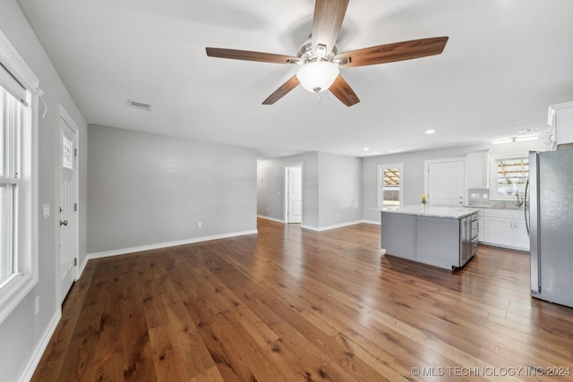 unfurnished living room with wood-type flooring and ceiling fan