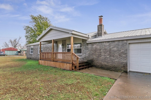 view of front of property with a garage, a porch, and a front lawn