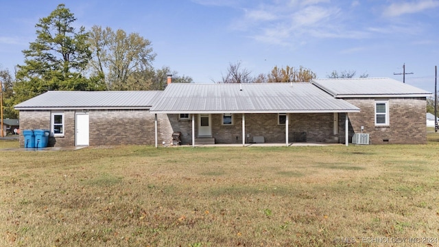 back of house featuring central AC unit and a yard