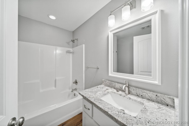 bathroom featuring hardwood / wood-style flooring, vanity, and shower / bath combination