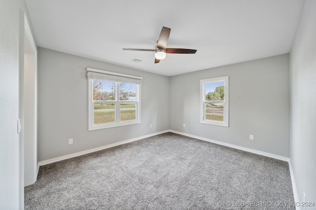 carpeted empty room featuring a wealth of natural light and ceiling fan