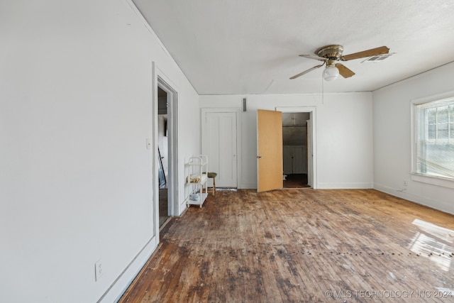 unfurnished bedroom featuring ceiling fan and dark hardwood / wood-style floors