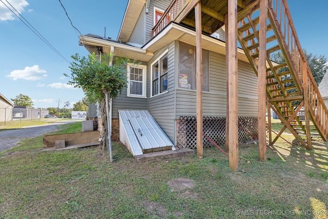 entry to storm shelter with central air condition unit and a lawn