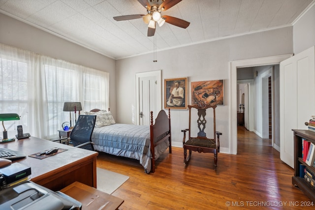 bedroom featuring hardwood / wood-style floors, ceiling fan, and crown molding