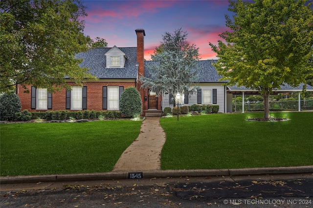 cape cod house featuring a yard