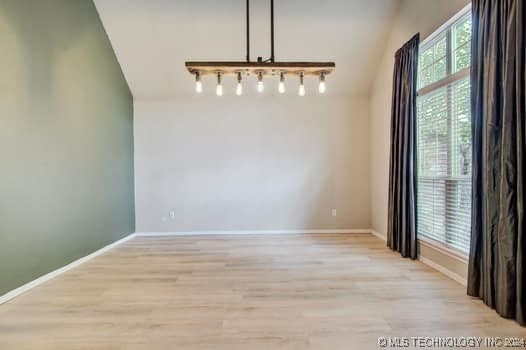 unfurnished dining area with light hardwood / wood-style flooring and lofted ceiling