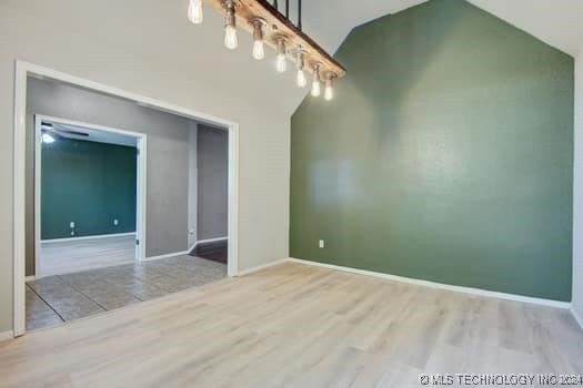 unfurnished room featuring vaulted ceiling and light hardwood / wood-style flooring