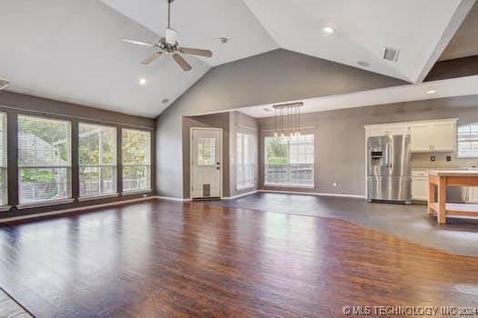 unfurnished living room featuring dark hardwood / wood-style flooring, ceiling fan, and plenty of natural light