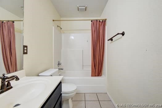 full bathroom with tile patterned flooring, vanity, shower / bath combo with shower curtain, and toilet