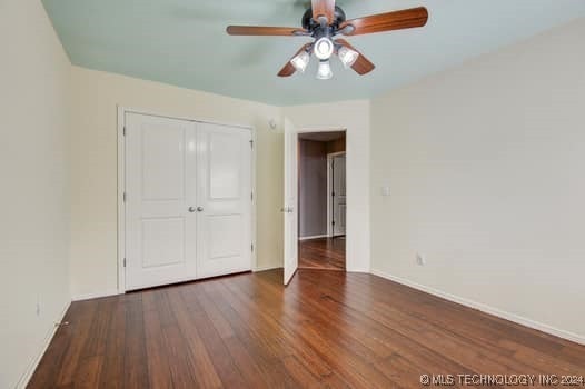 unfurnished bedroom with ceiling fan, a closet, and dark hardwood / wood-style flooring