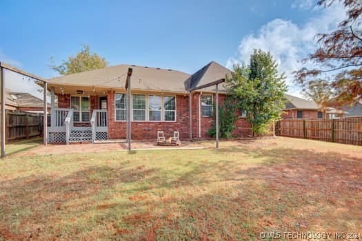 rear view of property featuring a patio and a lawn