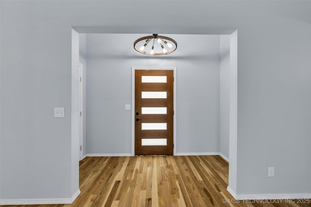 entrance foyer featuring light wood-type flooring and a notable chandelier