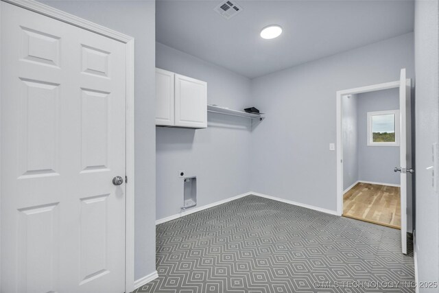 clothes washing area featuring cabinets, dark carpet, and electric dryer hookup