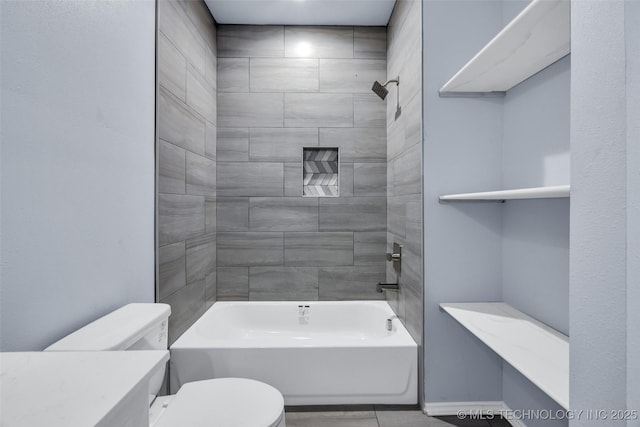 bathroom with toilet and tiled shower / bath