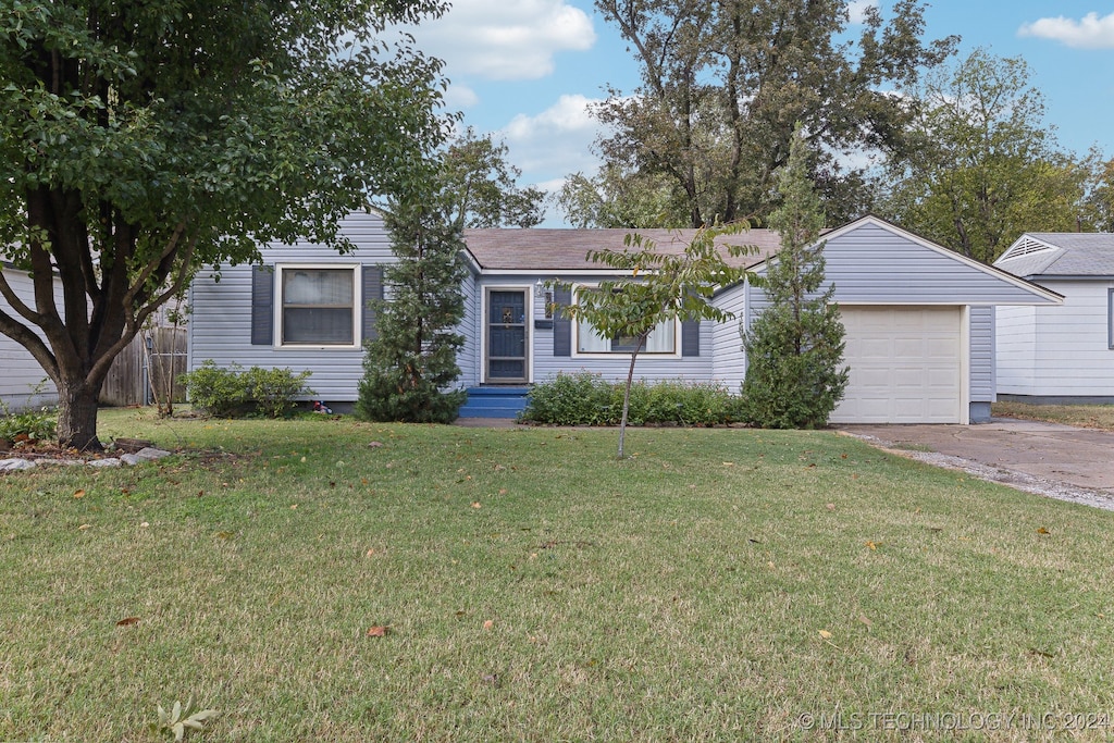 ranch-style house featuring a garage and a front yard