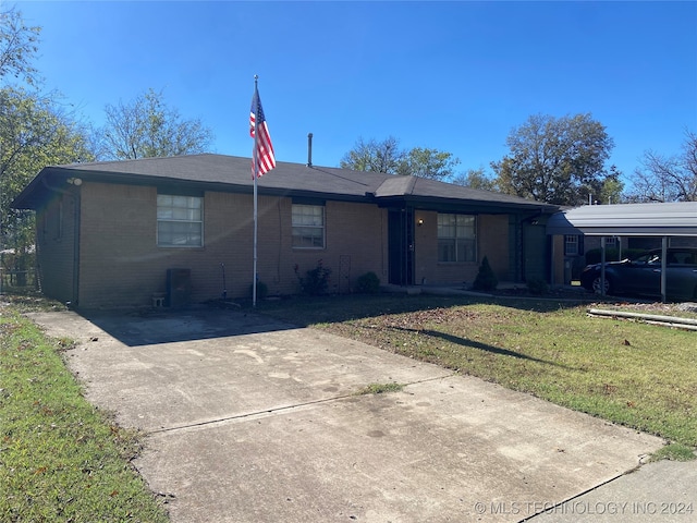 ranch-style home with a front yard and a carport