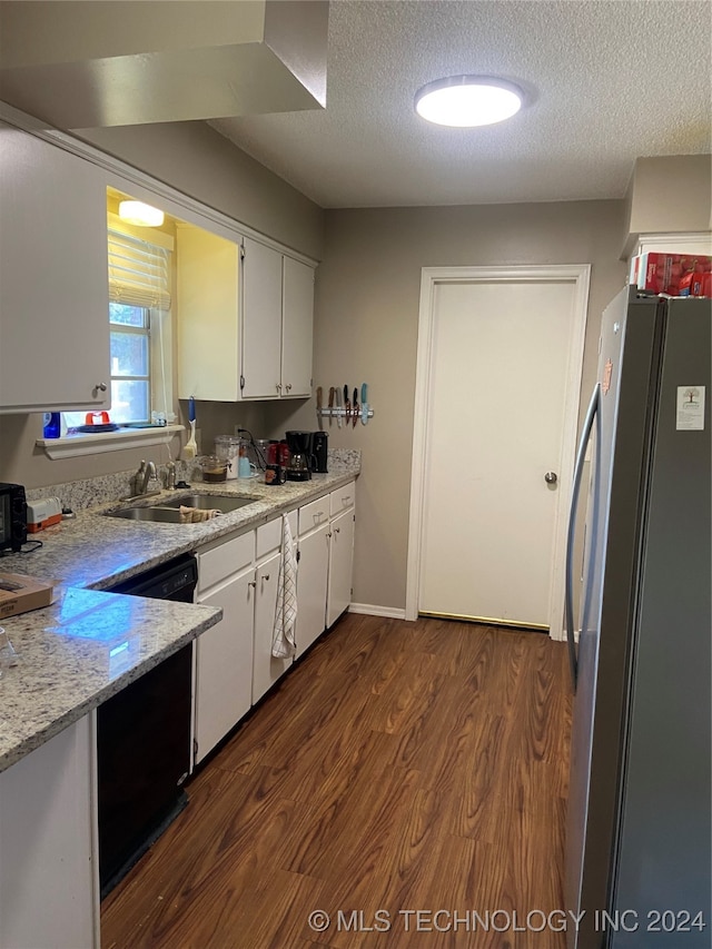 kitchen featuring dark wood-type flooring, white cabinets, a textured ceiling, sink, and stainless steel refrigerator