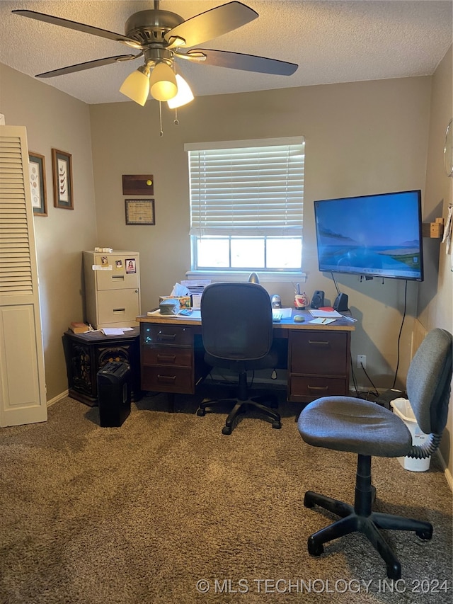 carpeted home office with a textured ceiling and ceiling fan