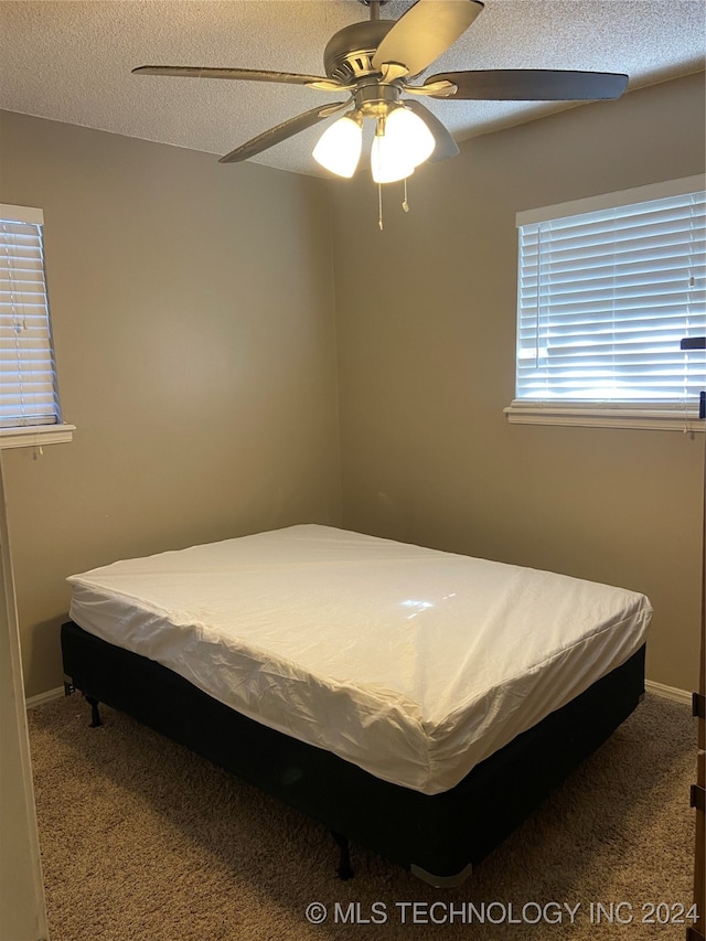 carpeted bedroom featuring a textured ceiling and ceiling fan