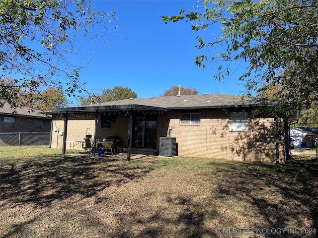 rear view of house with a patio, a yard, and central air condition unit