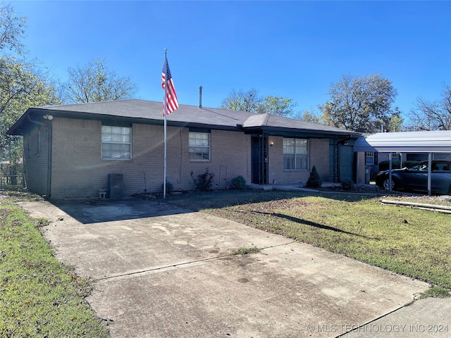 single story home featuring a front lawn and a carport