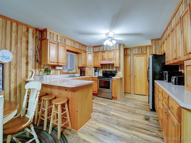 kitchen with kitchen peninsula, a kitchen breakfast bar, light brown cabinets, light hardwood / wood-style floors, and stainless steel range with electric cooktop