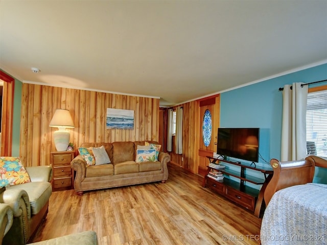 living room with wooden walls, hardwood / wood-style flooring, and crown molding