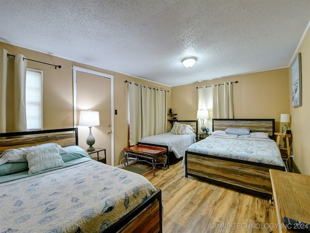 bedroom featuring light hardwood / wood-style flooring and a textured ceiling