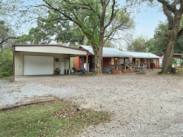 view of front facade featuring covered porch, an outbuilding, and a garage