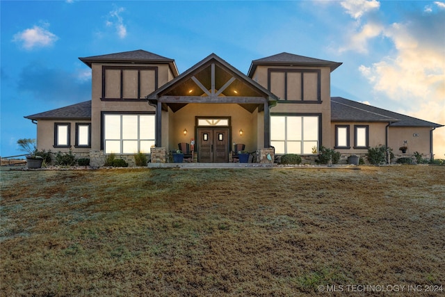 rear view of property with french doors and a lawn