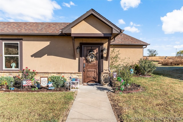 property entrance with a lawn