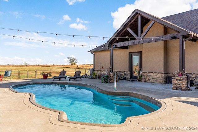 view of pool featuring a patio area and a rural view