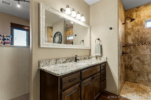 bathroom with vanity and a tile shower