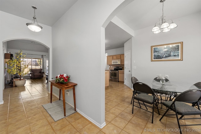 hall with light tile patterned floors and an inviting chandelier