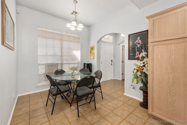 tiled dining room featuring an inviting chandelier