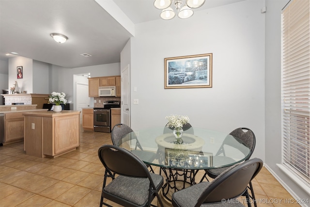 tiled dining room featuring a notable chandelier